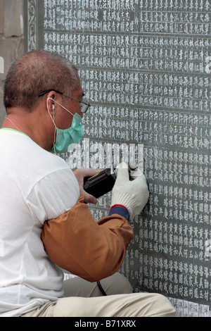 A craftsman carves the names of donators on the wall in Wenwu Temple which located at Sun Moon Lake Taiwan Stock Photo