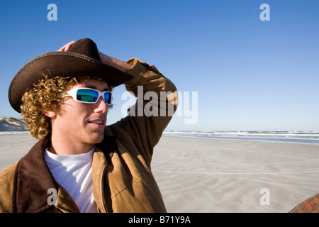 Close-up pf young man wearing sunglasses and cowboy hat at beach Stock Photo