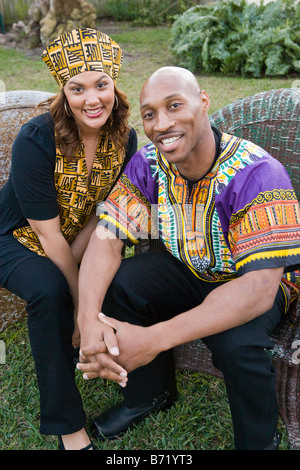 African American couple dressed in traditional African attire sitting outdoors Stock Photo