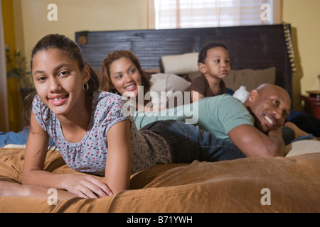 Happy African American family lying on bed Stock Photo