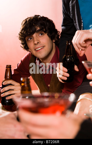 Young man drinking and socializing with friends Stock Photo