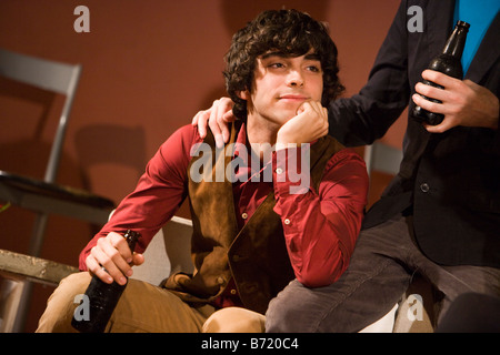 Close-up of young man daydreaming while having drinks with friends Stock Photo