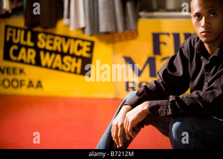 African American man sitting in front of sign Stock Photo