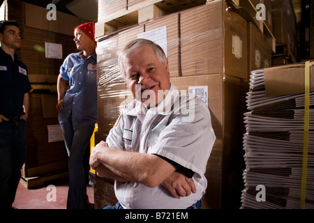 Three workers in storage warehouse Stock Photo