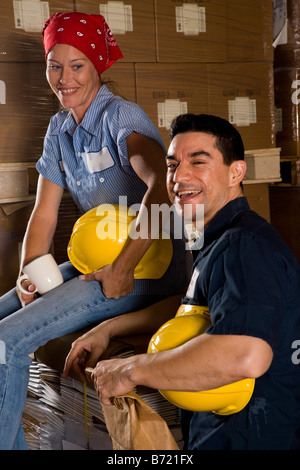 Two workers sitting in storage warehouse Stock Photo