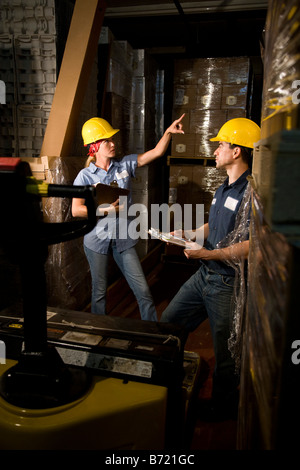 Two co-workers in storage warehouse working together Stock Photo