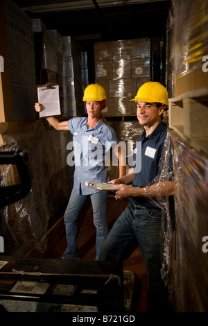 Two co-workers in storage warehouse working together Stock Photo
