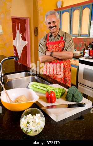 Middle-aged African-American man cutting vegetables in kitchen Stock Photo