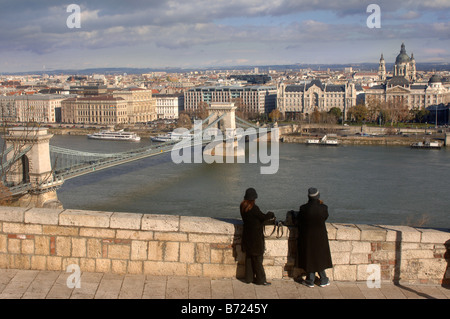 VIEW OF THE CHAIN BRIDGE FROM CASTLE HILL OVER THE RIVER DANUBE IN BUDAPEST HUNGARY LEADING TO THE GRESHAM PALACE HOTEL WITH THE Stock Photo