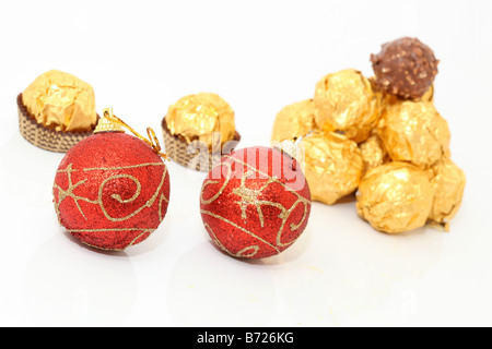 xmas balls and gold wraped chocolates isolated on white background Stock Photo