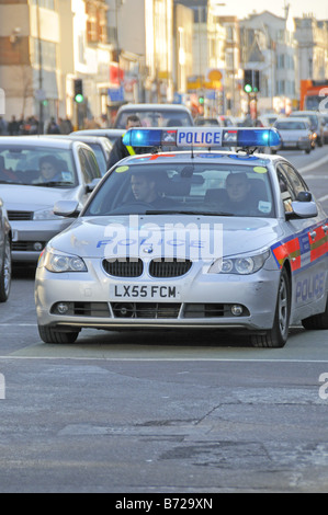 Police car with flashing blue lights in traffic Holloway Road Holloway Islington London England UK Stock Photo