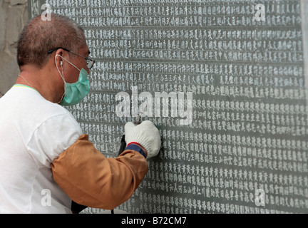 A craftsman carves the names of donators on the wall in Wenwu Temple which located at Sun Moon Lake Taiwan Stock Photo