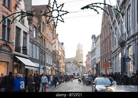 Shopping on Steenstraat in the old town centre at Christmas time with the cathedral behind, Bruges, Belgium Stock Photo