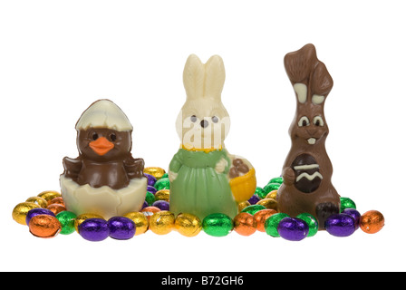 cute easter bunnies and chick surrounded by chocolate easter eggs isolated on a white background Stock Photo