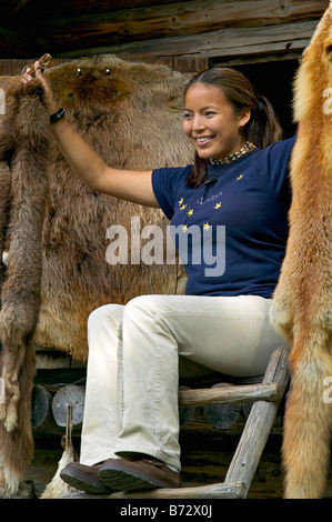 An Athabaskan indian girl displays furs on a tour in Alaska Stock Photo