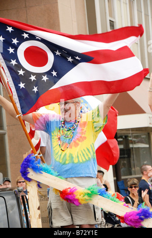 Man with tie dyed t-shirt waving Ohio State Flag in Gay Pride Parade Columbus Ohio 2008 Stock Photo