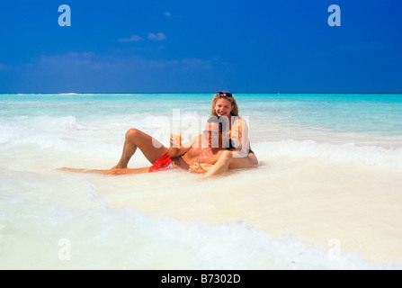 MALDIVE ISLANDS INDIAN OCEAN COUPLE HAVING FUN AT SURF Stock Photo
