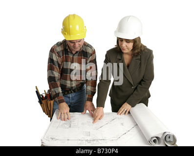 A female engineer and a building contractor reviewing blueprints Isolated on white Stock Photo