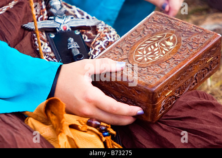 Image of a woman s hands holding a carved wooden box in her lap Stock Photo