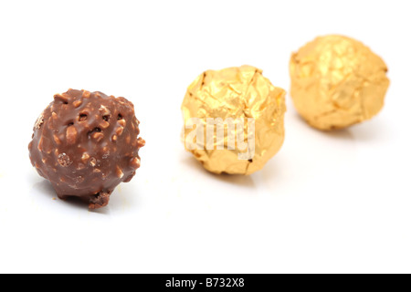 closeup chocolate sphere with nuts with two gold wraped isolated on white background Stock Photo
