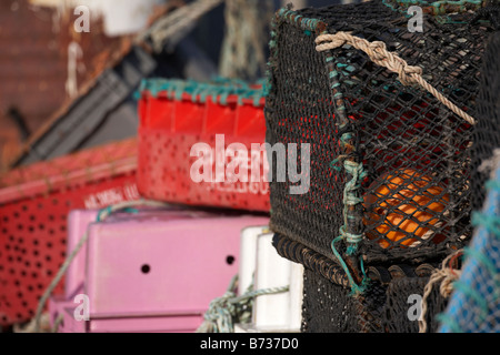 lobster pots and fishing crates piled up on a pier in portavogie county down Northern Ireland UK Stock Photo