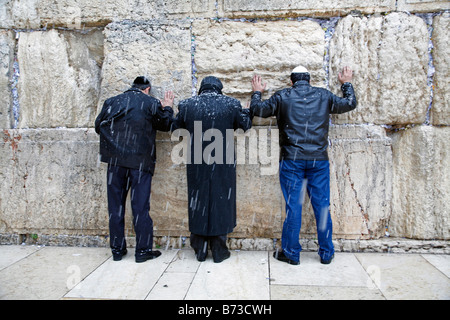 Religious Jews praying at the Western Wall in the Old City of Jerusalem during a snow storm. Stock Photo