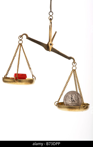 toy red house and one us quarter dollar 25c coin on balancing scales house higher Stock Photo