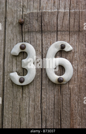 Number thirty six, no 36, # 36, posted on weathered wooden fence post Stock Photo