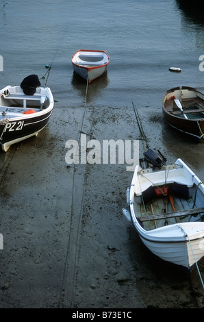 Small boats tethered over beach in Mousehole harbour, Cornwall Stock Photo