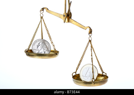 one us quarter dollar 25c coin and one euro coin on balancing scales quarter higher Stock Photo