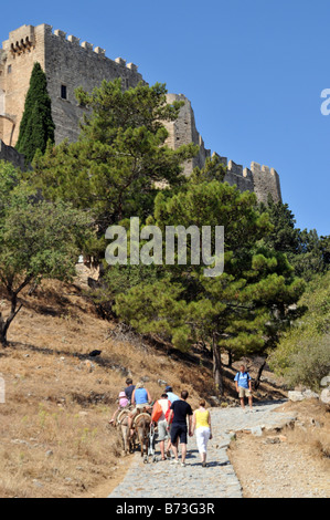 Tourist riding donkeys to the Ancient Acropolis in Lindos on the Greek Island of Rhodes Stock Photo