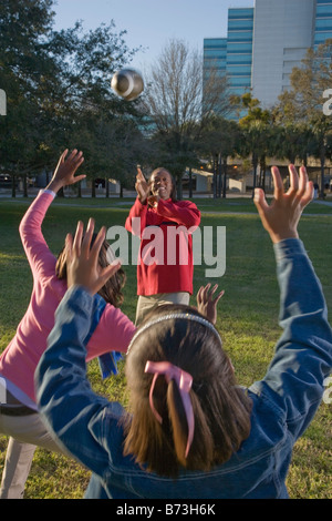 African American family playing football in park Stock Photo