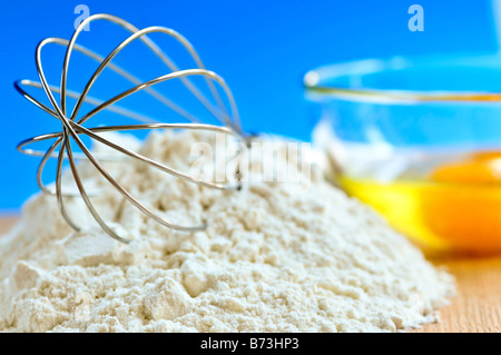 Flour whisk and eggs in a bowl baking ingredients Stock Photo