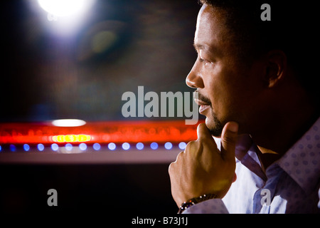 Close-up of young African American man with hand on chin at bar Stock Photo