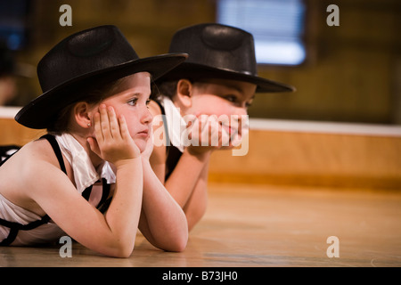 Girls in costume lying on dance studio floor Stock Photo