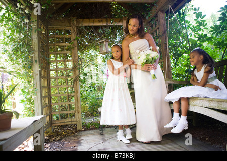 Happy African-American bride with flower girls in gazebo on wedding day Stock Photo