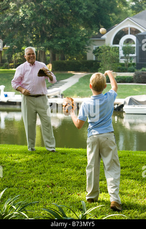 Grandfather and son playing baseball in back yard Stock Photo