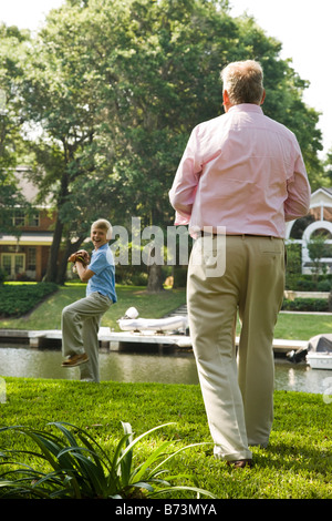 Grandfather and son playing baseball in back yard Stock Photo