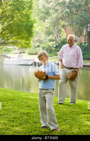 Grandfather and son playing baseball in back yard Stock Photo