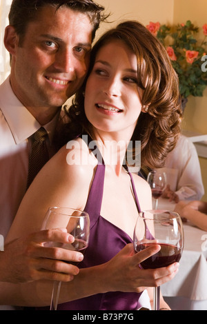 Attractive well-dressed couple drinking wine in restaurant Stock Photo