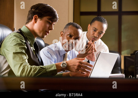Employees assisting African-American executive reviewing paperwork Stock Photo