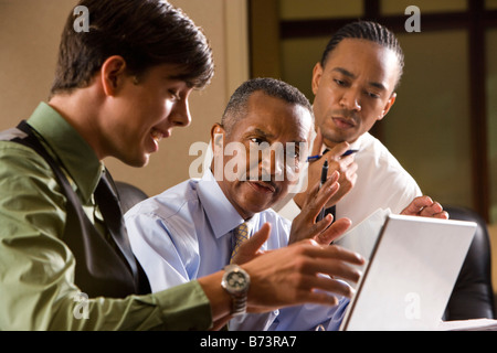 Employees assisting African-American executive reviewing paperwork Stock Photo