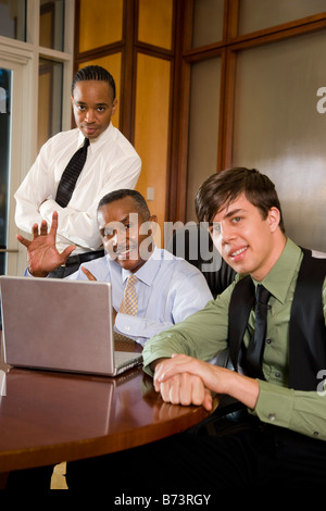 African-American executive and two young co-workers with laptop Stock Photo