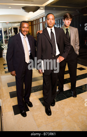 Multi-racial businessmen walking through lobby of office building Stock Photo