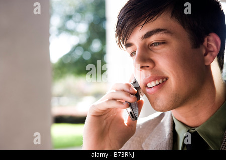 Young man outside building talking on mobile phone Stock Photo