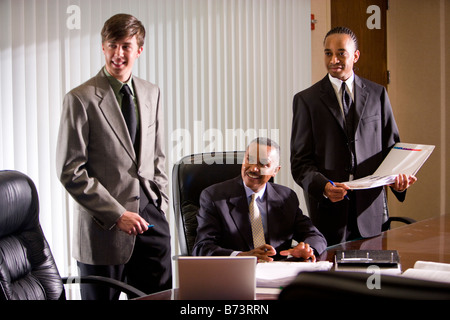 African-American businessman with two young colleagues working in office Stock Photo