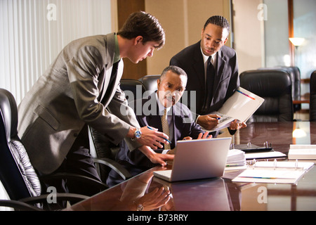 African-American businessman with two young colleagues working in office Stock Photo