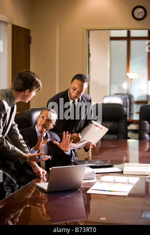 African-American businessman with two young colleagues working in office Stock Photo