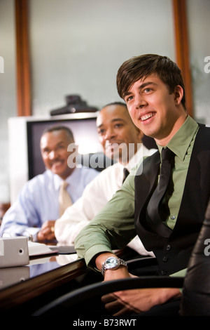 Three multi-racial businessmen in boardroom meeting Stock Photo