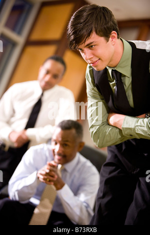 Close-up of young businessman,  with African-American businessmen behind Stock Photo